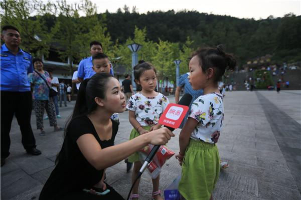 美女主播在《印象武隆》剧场前采访小朋友（图/王俊杰）